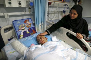 Ahmed Dawanshe's grandmother Satira stands by his bed in the Tel Hashomer hospital near the city of Tel Aviv, December 3, 2015. Ahmed Dawabshe, a 4-year-old Palestinian boy, suffered severe burns in an arson attack on his family home in the Israeli-occupied West Bank home that Israel suspects was carried out by far right Jewish assailants last July and in which his younger brother, Ali, and his parents both died. Israel announced on Thursday that a number of suspects were in custody after a recent breakthrough in the investigation in the case that has prompted Israel to crack down harder on violent far-right Jewish groups. REUTERS/Ammar Awad - RTX1X2TA