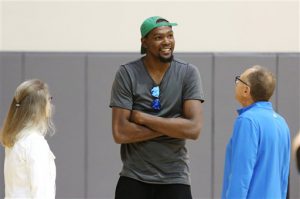 Kevin Durant, centro, conversa con el asistente de los Warriors, Ron Adams, derecha, antes de una conferencia de prensa para presentarlo como nuevo jugador de Golden State el jueves, 7 de julio de 2016, en Oakland, California. (AP Photo/Beck Diefenbach)