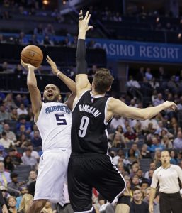 Nicolas Batum, de los Hornets de Charlotte, realiza su tiro frente al italiano Andrea Bargnani, de los Nets de Brooklyn, durante el encuentro disputado el miércoles 18 de noviembre de 2015 (AP Foto/Chuck Burton)