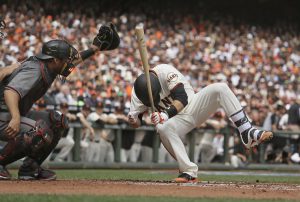 Buster Posey, de los Gigantes de San Francisco, cae tras ser golpeado por un lanzamiento de Taijuan Walker, de los Diamondbacks de  Arizona, en el encuentro del lunes 10 de abril de 2017 (AP Foto/Eric Risberg)