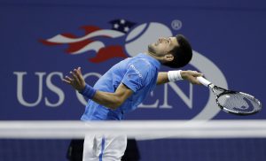 Novak Djokovic, of Serbia, serves to Jo-Wilfried Tsonga, of France, during the quarterfinals of the U.S. Open tennis tournament, Tuesday, Sept. 6, 2016, in New York. Djokovic advanced when Tsonga retired from the match. (AP Photo/Darron Cummings)