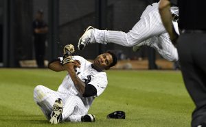 El jugador de los Medias Blancas, Willy García, en el suelo, es golpeado en la cabeza por la rodilla de su compañero Yoan Moncada, centro, durante un partido contra los Azulejos de Toronto el lunes, 31 de julio de 2017, en Chicago. (AP Photo/David Banks)