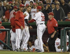 Washington Nationals' Bryce Harper, center, is restrained by pitching coach Mike Maddux, left, and hitting coach Rick Schu (39) after Harper was ejected in the dugout during the ninth inning of an interleague baseball game against the Detroit Tigers, Monday, May 9, 2016, in Washington. The Nationals won 5-4. (AP Photo/Nick Wass)