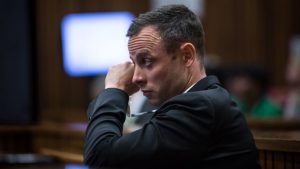 Oscar Pistorius, wipes his eye during crime scene photographs as he sits in the dock in court in Pretoria, South Africa, Monday, March 17, 2014. Pistorius is on trial for the murder of his girlfriend Reeva Steenkamp on Valentines Day, 2013. (AP Photo/Daniel Born, Pool)